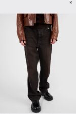 Stile streetwear con pantaloni larghi, giacca in pelle e scarpe chunky.