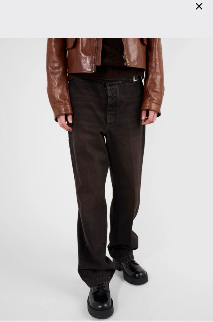Stile streetwear con pantaloni larghi, giacca in pelle e scarpe chunky.
