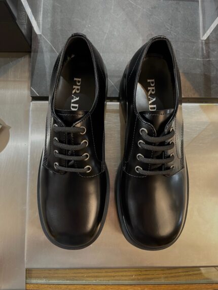 Scarpe Prada classiche in pelle lucida da uomo, elegante e di alta qualità.