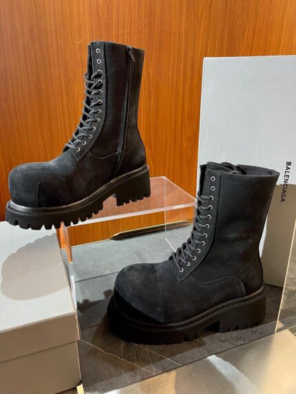 Stivali neri rugged ed eleganti, stile urbano e moderno, con suola spessa e lacci metallici.