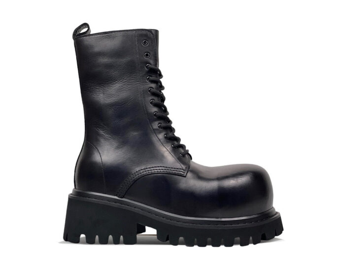 Stivaletti combat neri in pelle lucida, stile moderno e robusto, con suola spesso e supporto elevato.