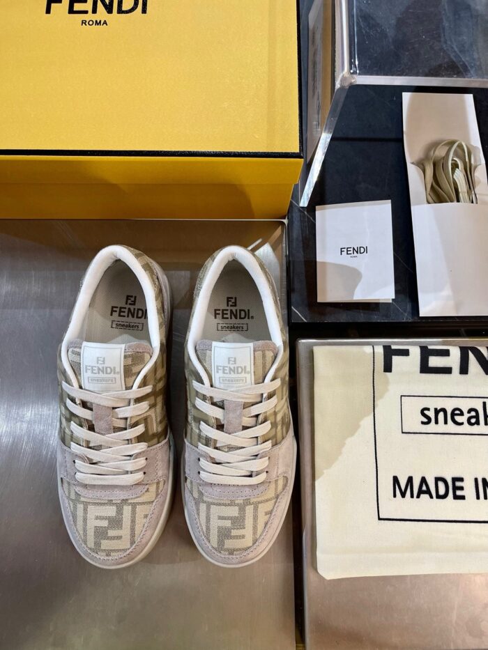 Sneakers Fendi di lusso con scatola gialla e dettagli eleganti su superficie metallica.