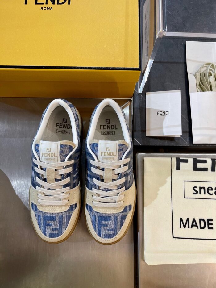 Sneakers Fendi blu e bianco con confezione gialla e dettagli eleganti, stile di lusso e moda.