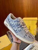 Sneaker di lusso in suede grigio con dettagli eleganti, sfondo con scatole gialle stilose.