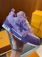 Sneaker di lusso viola con logo giocoso e packaging esclusivo, perfetta stile casual e fashion.