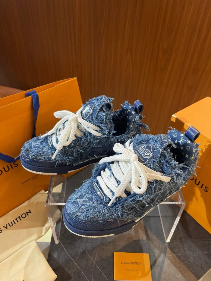 Sneaker in denim blu con dettagli di lusso, packaging elegante e stile streetwear.