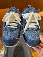 Sneakers in denim distressed di lusso con logo discreto e stile streetwear moderno.