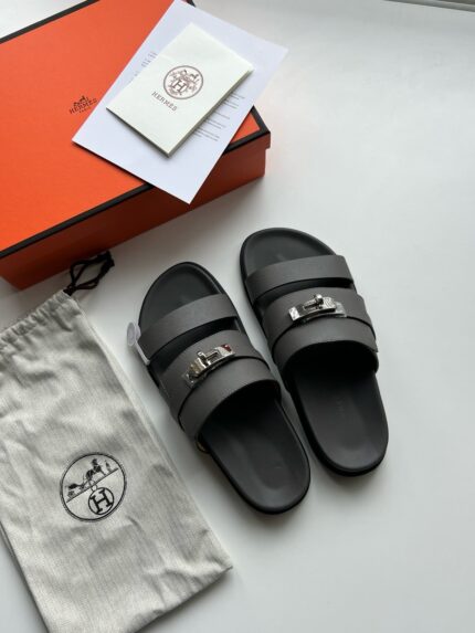 Sandali neri di lusso con dettagli metallici e packaging elegante in stile premium.