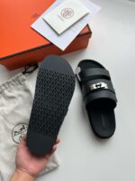 Sandali neri di lusso con dettagli moderni, confezione elegante e pratico sacchetto per viaggio.