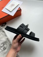 Sandali neri di lusso con dettagli metallici, presentati con scatola elegante e dust bag.