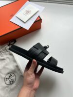 Sandali neri minimalisti con confezione di lusso, packaging elegante, stile moderno e raffinato.