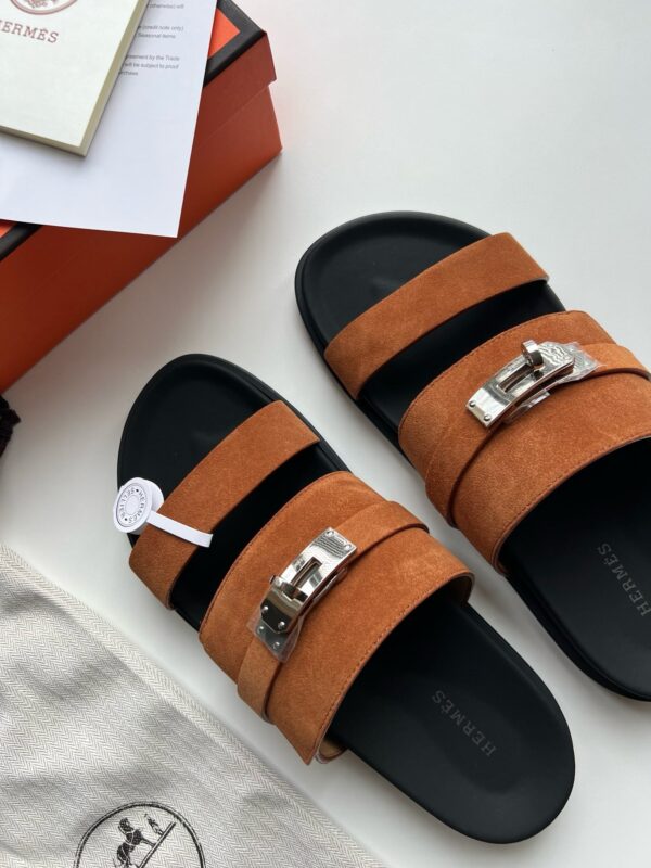 Sandali in camoscio arancione con fibbia metallica, stile elegante e versatile per ogni abbigliamento.