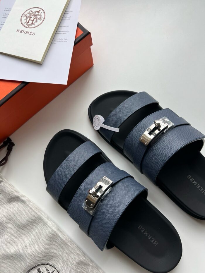 Sandali navy di lusso con fibbie metalliche e packaging elegante, accessori di alta moda.