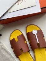 Sandali di lusso marroni con dettaglio giallo, design elegante e comfort casual.