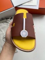 Sandalo slide moderno con suola gialla e dettaglio logo nautico, stile e comfort raffinato.
