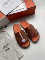 Sandali slide eleganti in tonalità earthy con dettagli di lusso e design moderno.