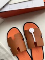 Sandali moderni con dettagli bianchi, suola arancione e design elegante e confortevole.