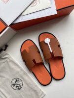 Sandali di lusso marroni e arancioni con pouch elegante e imballaggio raffinato.