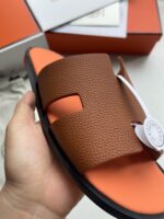 Sandalo di lusso con design moderno, dettagli in arancione e comoda suola imbottita.