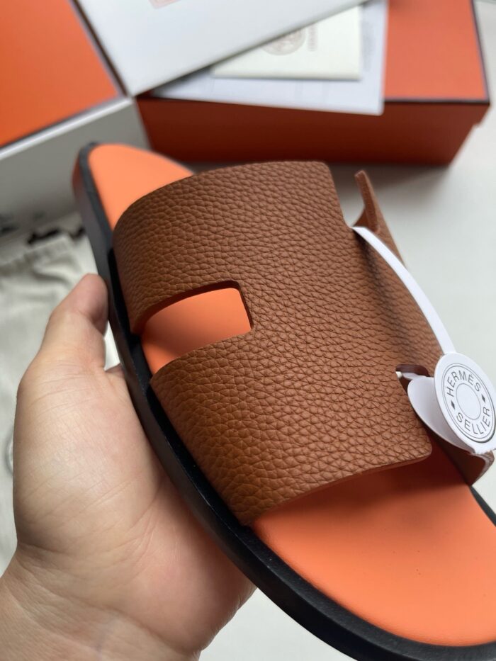 Sandalo di lusso con design moderno, dettagli in arancione e comoda suola imbottita.