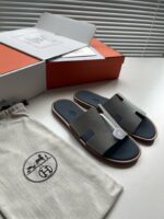 Sandali di lusso con pochette bianca e confezione elegante su superficie minimalista.