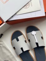 Sandali di lusso moderni con suola navy, packaging elegante e dettagli raffinati per l’estate.
