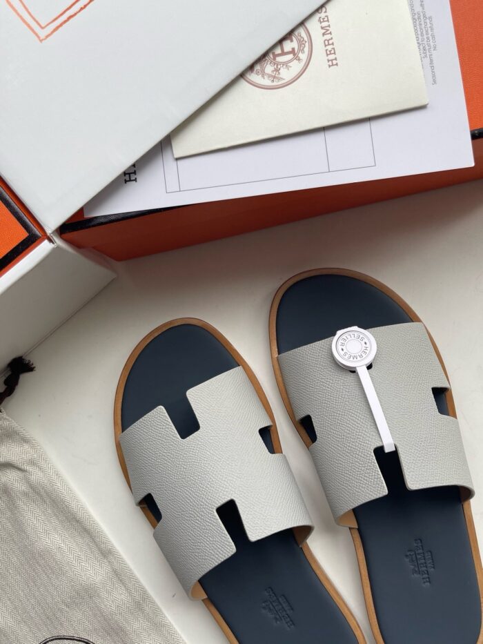 Sandali di lusso moderni con suola navy, packaging elegante e dettagli raffinati per l’estate.