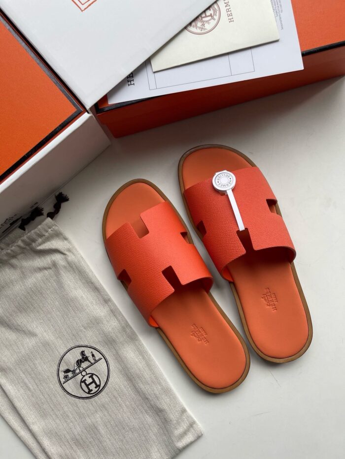 Sandali arancioni di design con borsa elegante e packaging di lusso raffinato.