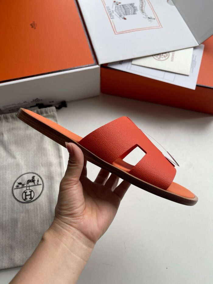 Sandali arancioni di lusso con confezione elegante e dettagli di alta qualità.