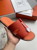 Sandali arancioni di lusso con dettaglio H, design moderno e qualità premium.