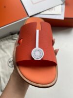Sandali orange slide con logo firma, design moderno e comfort elegante per stile casual sofisticato.