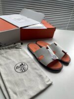 Sandali di lusso minimalistici con packaging elegante e dettagli colorati, ideale per uno stile sofisticato.