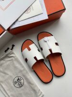 Sandali bianchi di lusso con suola arancione, design elegante e dettagli moderni per ogni occasione.