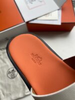 Sandalo slide di lusso con sole arancione, packaging elegante e dettagli raffinati.