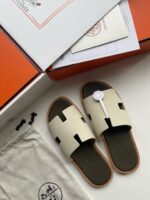 Sandali di lusso beige con dettagli moderni, firma e accessori eleganti per uno stile esclusivo.