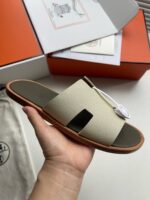 Sandali minimalisti di lusso con suola in cuoio e confezione elegante, perfetti per l’estate.