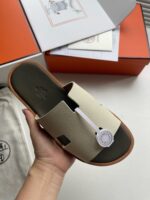 Sandalo beige di lusso con packaging elegante e tag distintivo, stile raffinato e moderno.