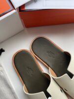 Sandali slip-on eleganti in crema con suola robusta e packaging di lusso.