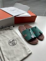 Sandali verdi eleganti con borsa in cotone e packaging arancione, stile moderno e raffinato.