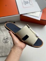 Sandalo di lusso beige con dettaglio nero, suola in cuoio, stile elegante e contemporaneo.