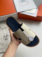 Sandalo di lusso con dettagli eleganti, su sfondo neutro e packaging raffinato.