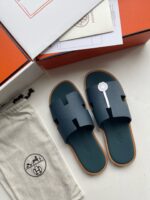Sandali di lusso blu navy, elegante packaging e dust bag in stile minimalista.