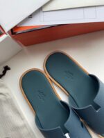 Sandali slide minimalisti in tela verde blu con dettaglio in legno, stile casual ed elegante.