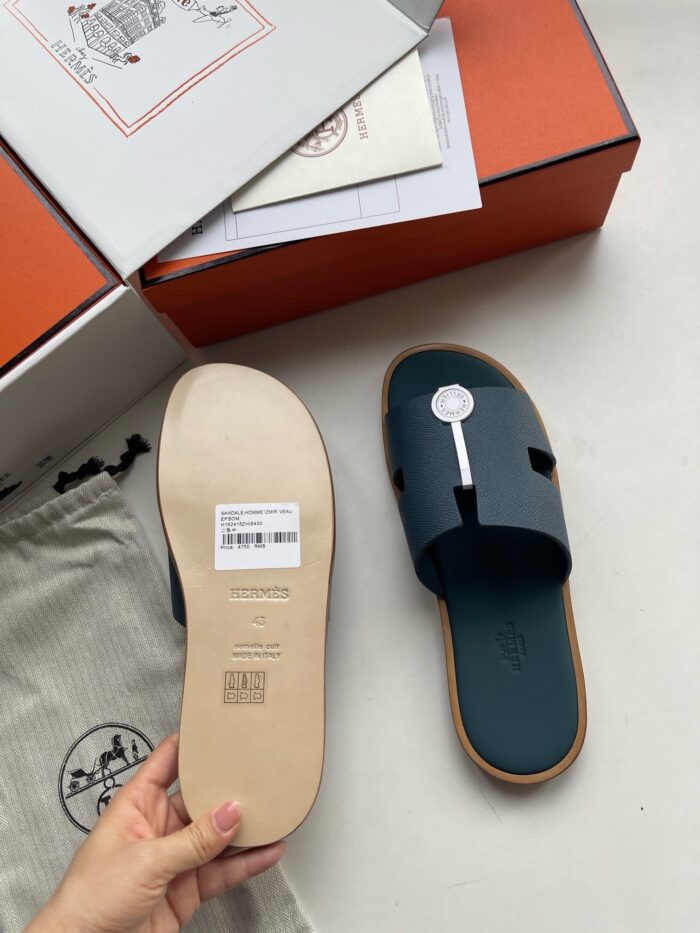 Sandali di lusso moderni con suola beige e strap blu con logo minimalista.