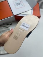 Scarpa di lusso con suola in pelle, box arancione e dettagli eleganti.