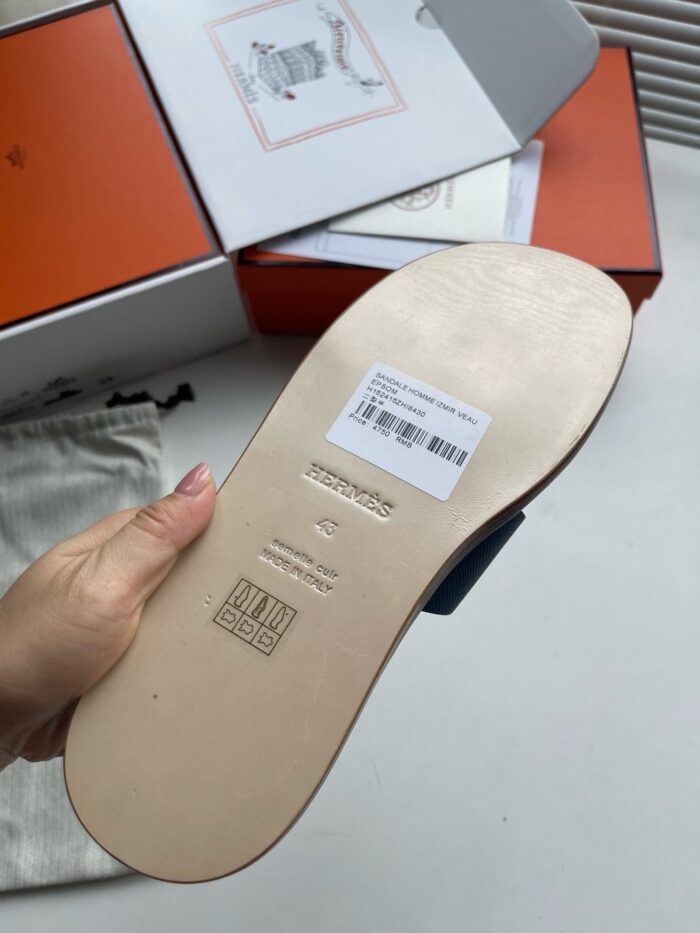 Scarpa di lusso con suola in pelle, box arancione e dettagli eleganti.