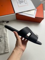 Sandalo nero moderno con dettaglio quadrato, confezione di lusso e dust bag elegante.