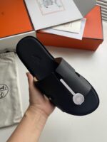 Sandalo minimalista in pelle nera di lusso, elegante e confortevole, con confezione di alta qualità.