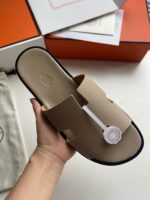 Sandali donna eleganti con logo iconico, design minimalista, suola nera e finitura raffinata.