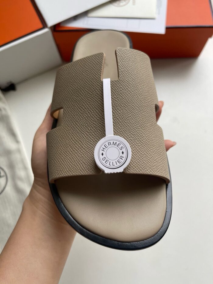 Sandali beige Hermès con logo, stile elegante e comfort estivo, ideale per look casual raffinati.
